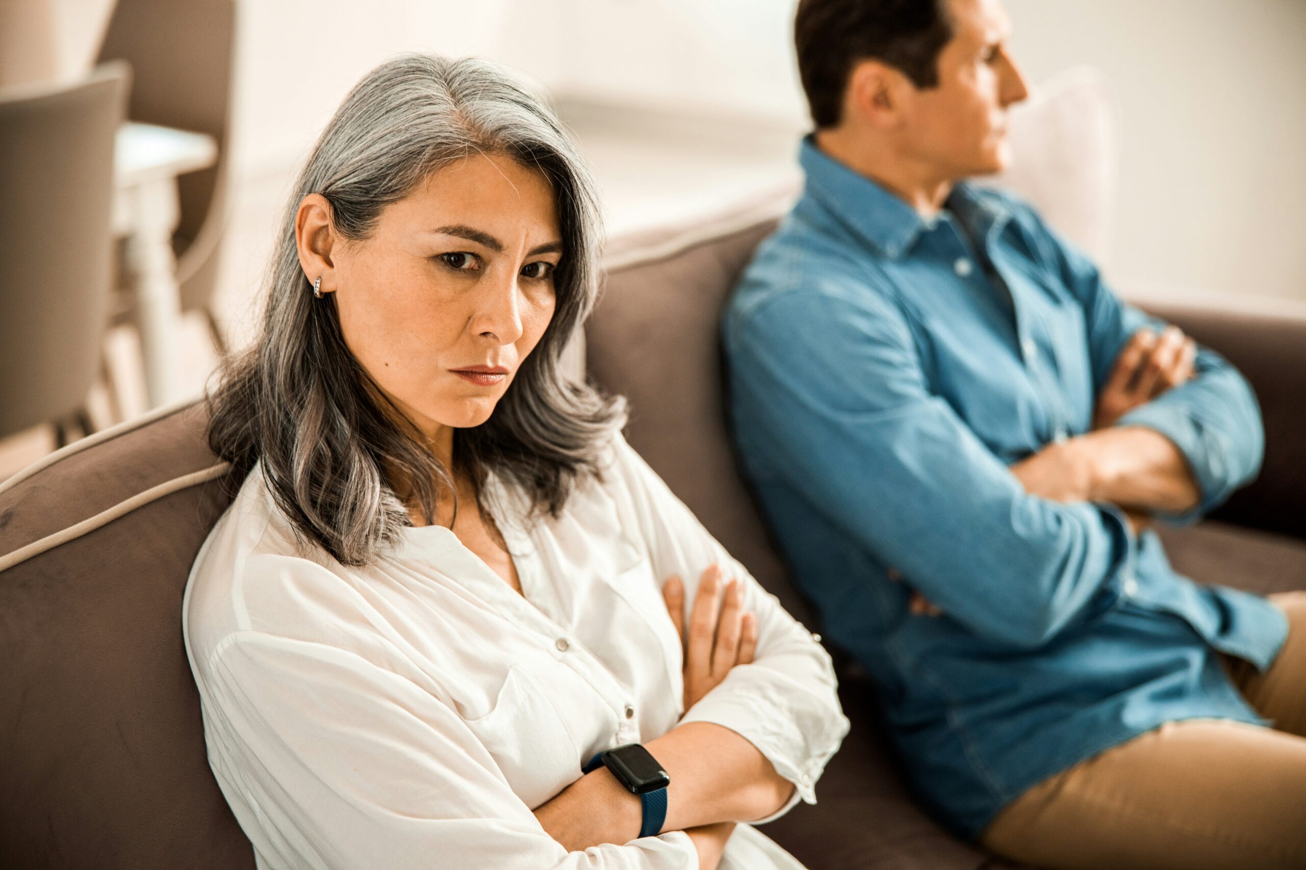 Couple sitting on a couch looking away from each other