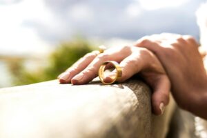 Person resting their hand near a wedding ring.