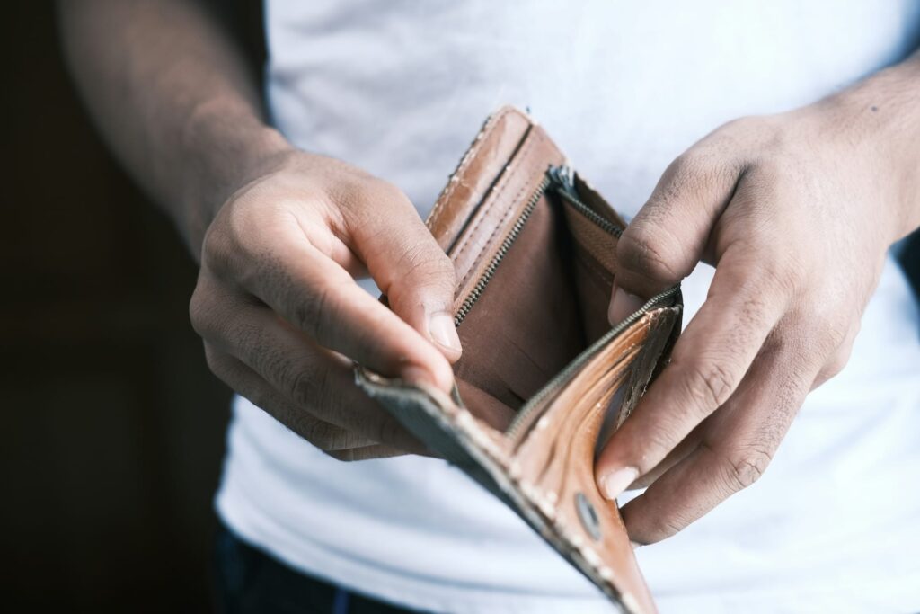 A person opening up their wallet, which is empty